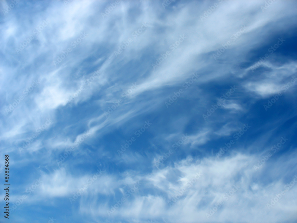 Blue sky background with wavy fleecy clouds