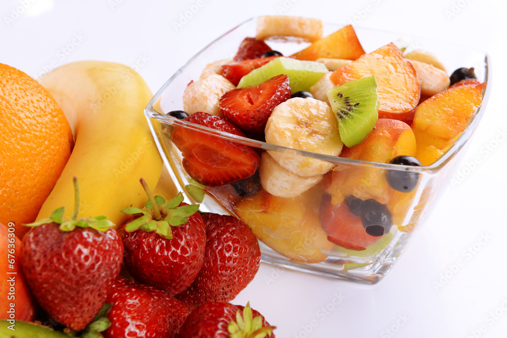 Fresh fruits salad in bowl with fruits and berries close up Fresh fruits salad in bowl with fruits and berries close up