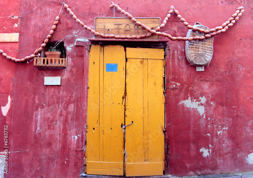 Una porta gialla su sfondo rosso a Procida photo