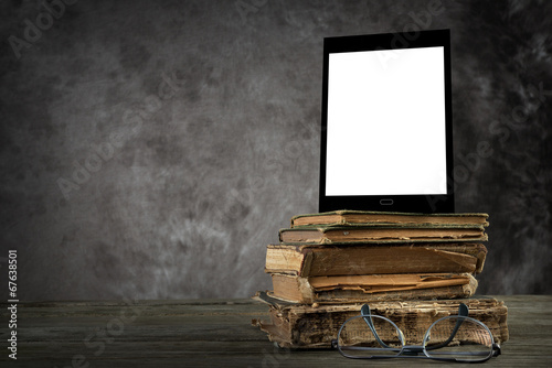 Old books with self-designed tablet computer and reading glasses photo