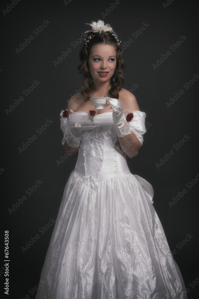 Victorian fashion woman wearing white dress. Holding porcelain t Victorian fashion woman wearing white dress. Holding porcelain t