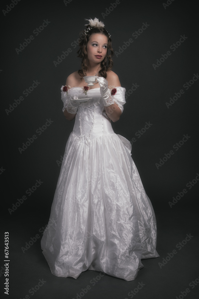 Victorian fashion woman wearing white dress. Holding porcelain t Victorian fashion woman wearing white dress. Holding porcelain t