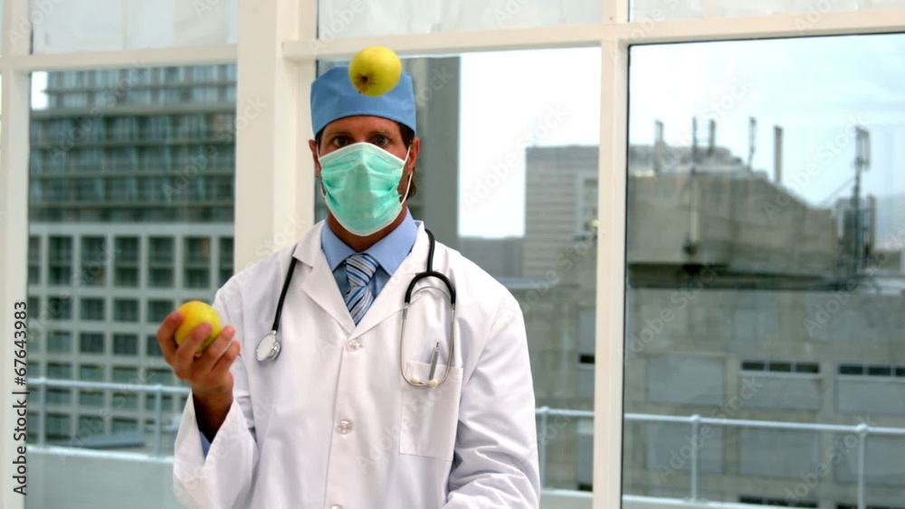 Doctor in mask juggling green apples Doctor in mask juggling green apples
