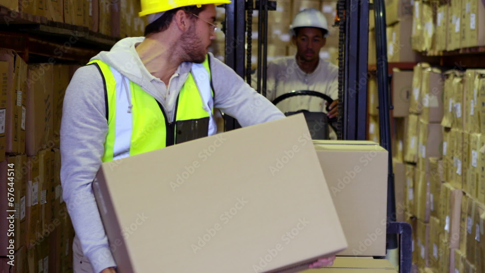 Warehouse worker packing boxes on forklift Warehouse worker packing boxes on forklift