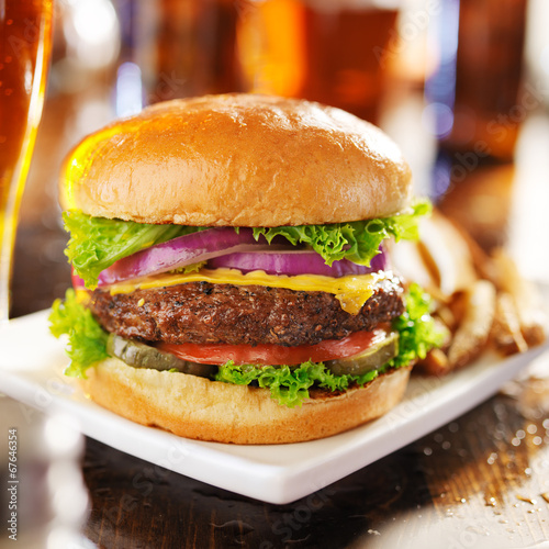 cheeseburger with beer and french fries close up
