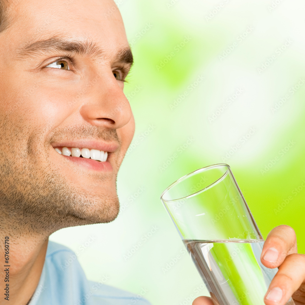 Young smiling man with glass of water, outdoors Young smiling man with glass of water, outdoors