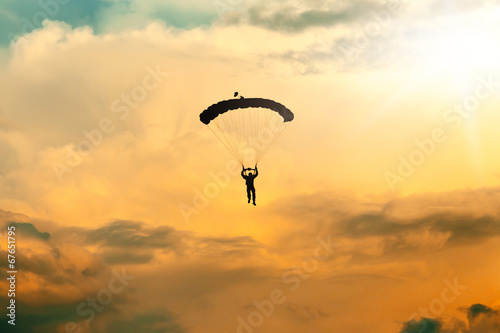 Fotografiet unidentified skydiver, parachutist on sky