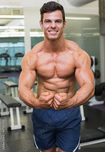 Shirtless muscular man flexing muscles in gym © WavebreakMediaMicro
