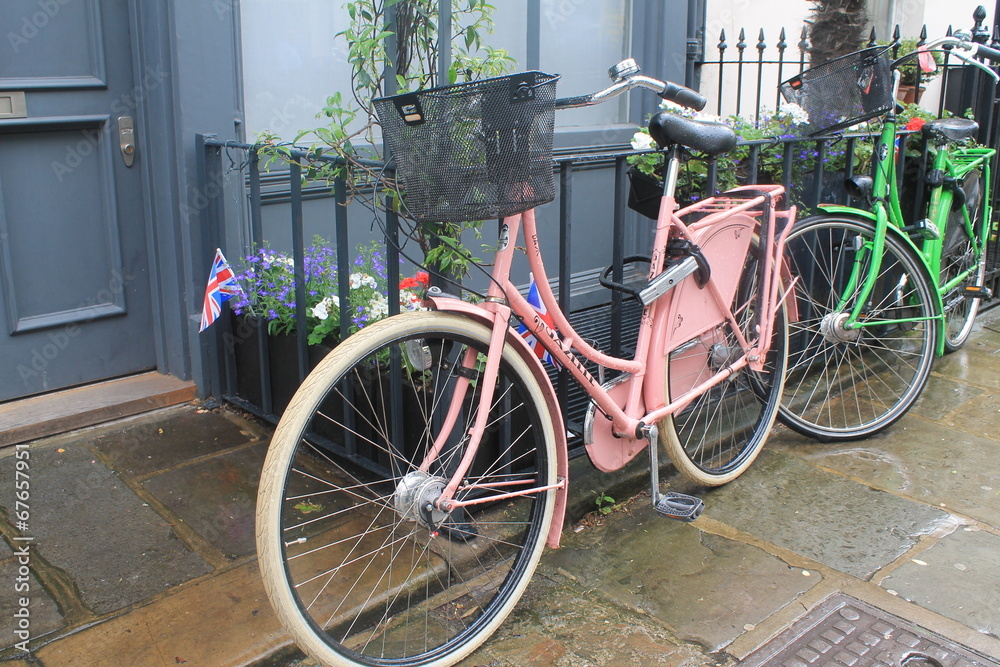 Pink  and green bicycles by the door with the british flag