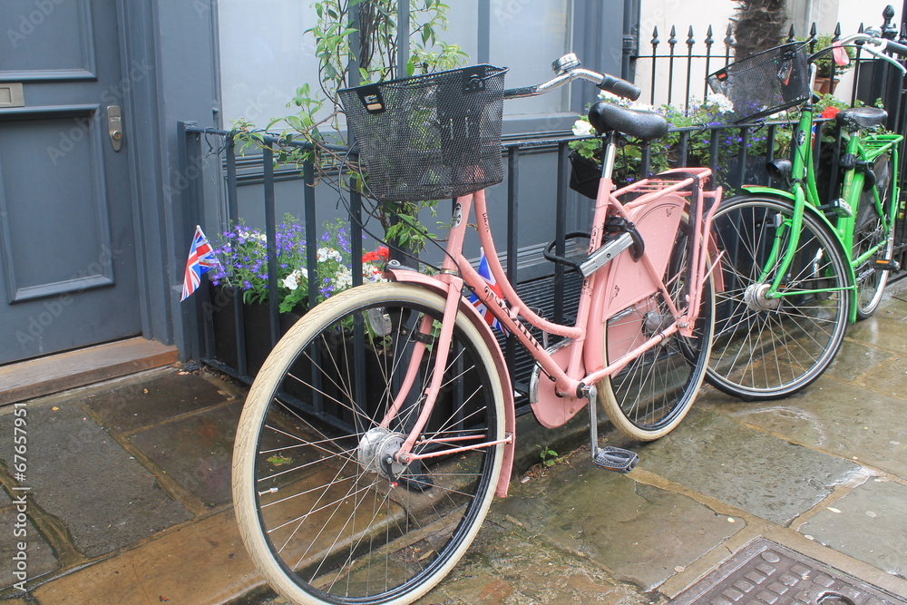 Pink and green bicycles by the door with the british flag Pink and green bicycles by the door with the british flag