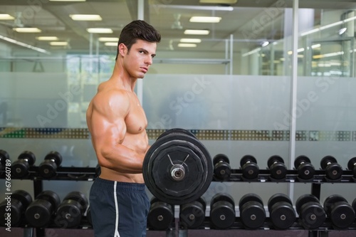 Fototapeta Naklejka Na Ścianę i Meble -  Shirtless muscular man lifting barbell in gym