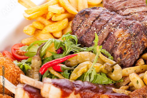 Platter of mixed meats, salad and French fries