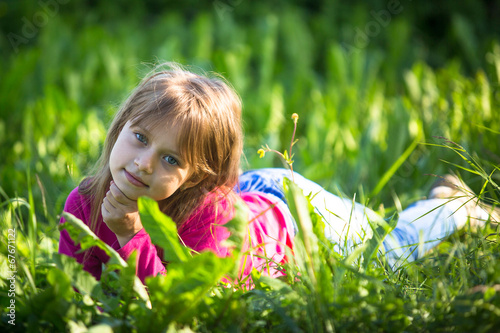 Portrait of little girl in the grass outdoors.