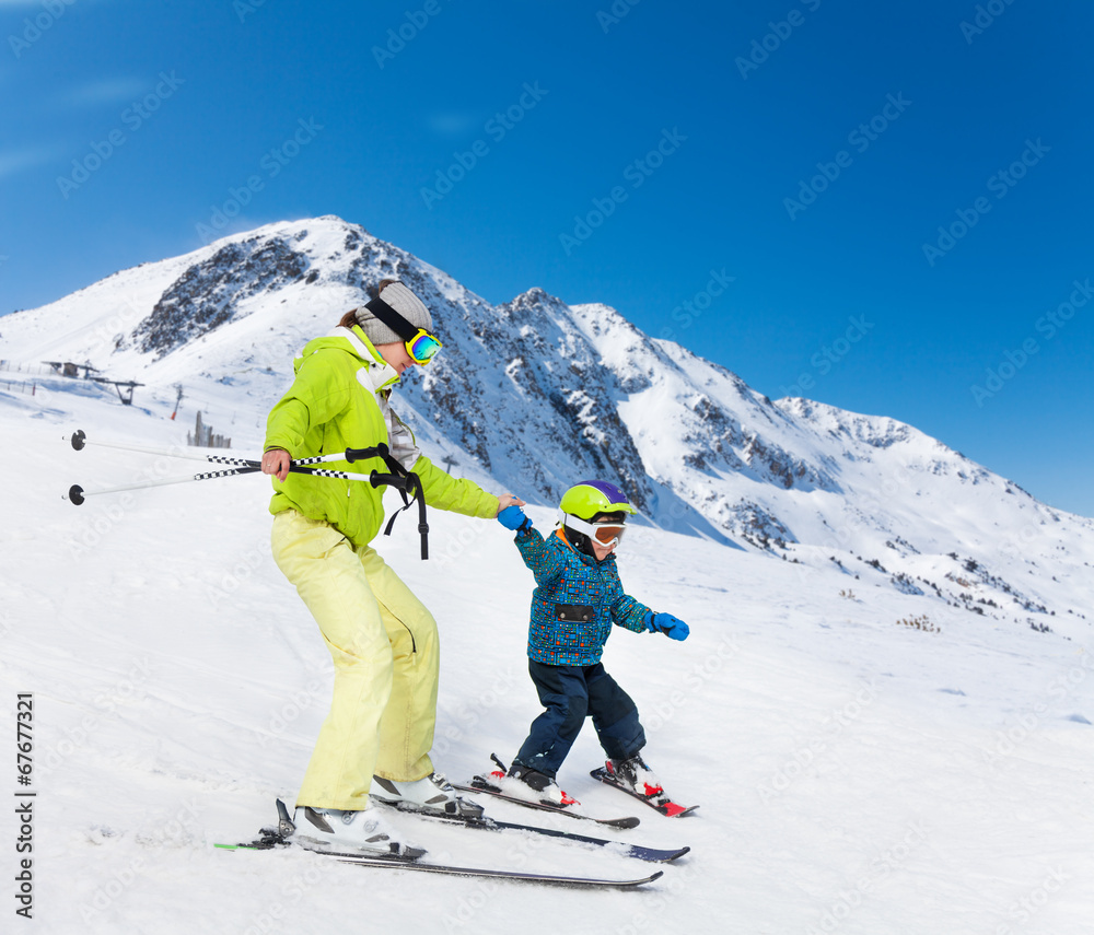 Instructor and kid skiing down the mountain
