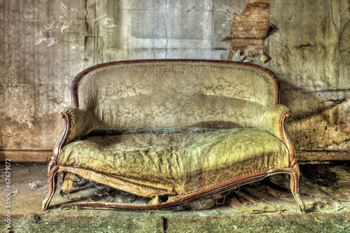 Rotten sofa in an abandoned house photo