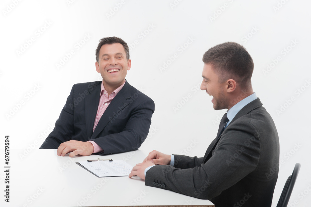 Two business people in elegant suits, chief and employee, holdin Two business people in elegant suits, chief and employee, holdin