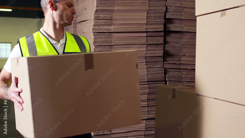 Warehouse worker stacking cardboard boxes