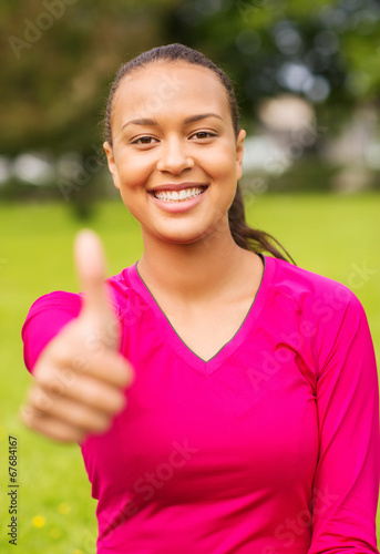 smiling african american woman showing thumbs up