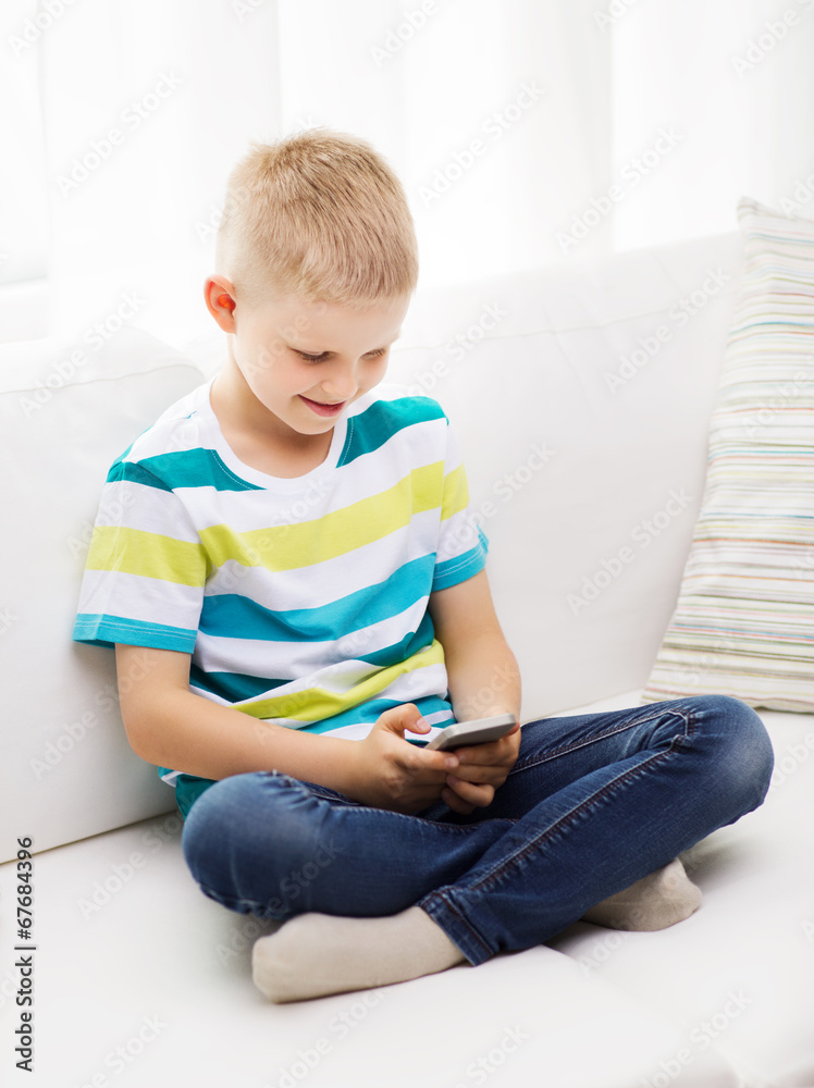 smiling little boy with smartphone at home smiling little boy with smartphone at home