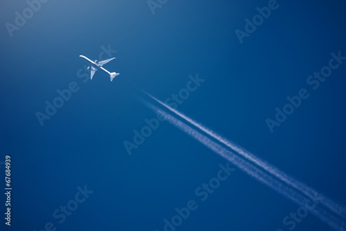 Fotografia Airliner at high altitude with white condesation trails