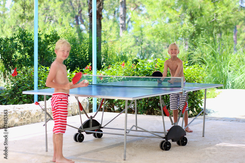 Fotografia Two happy boys playing ping pong outdoors