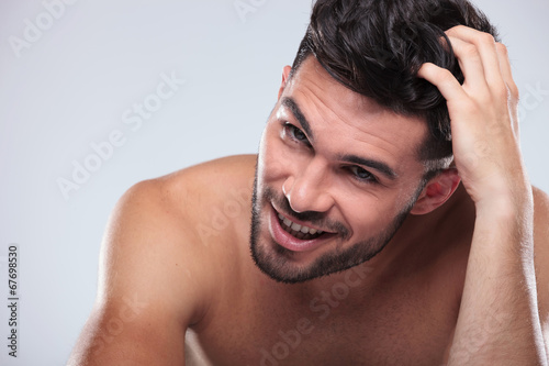 happy naked man scratching his head and smiles