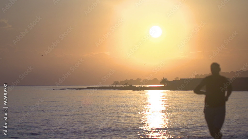 Man jogging at sunrise, steadycam shot, slow motion shot Man jogging at sunrise, steadycam shot, slow motion shot