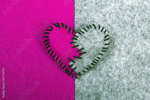 Φωτογραφία stitched broken felt heart on a on a two-color background