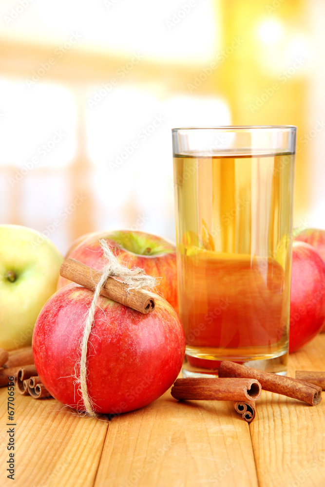 Ripe apples with with cinnamon sticks and glass of apple drink Ripe apples with with cinnamon sticks and glass of apple drink