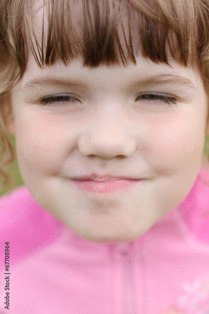 Close up of face little beautiful happy grimacing girl in pink Close up of face little beautiful happy grimacing girl in pink