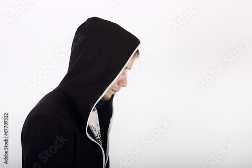 Profile of young man in black hoodies looking away in studio