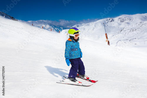 Small boy in ski mask and helmet skiing