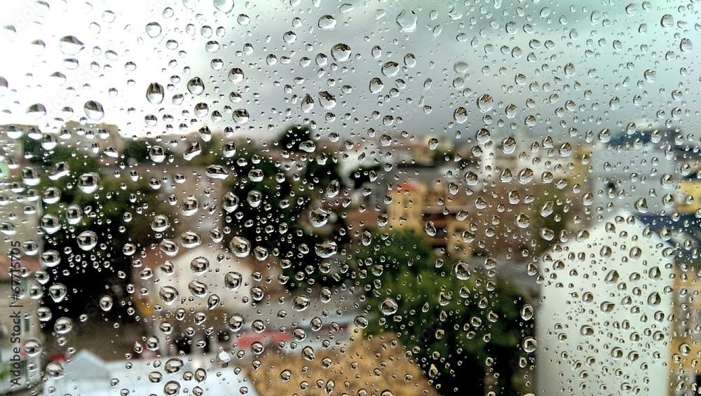 Wet rainy window glass with blurred town outside - obrazy, fototapety, plakaty 