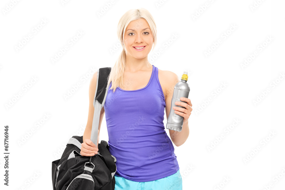 Female athlete holding a water bottle and carrying a sports bag Female athlete holding a water bottle and carrying a sports bag