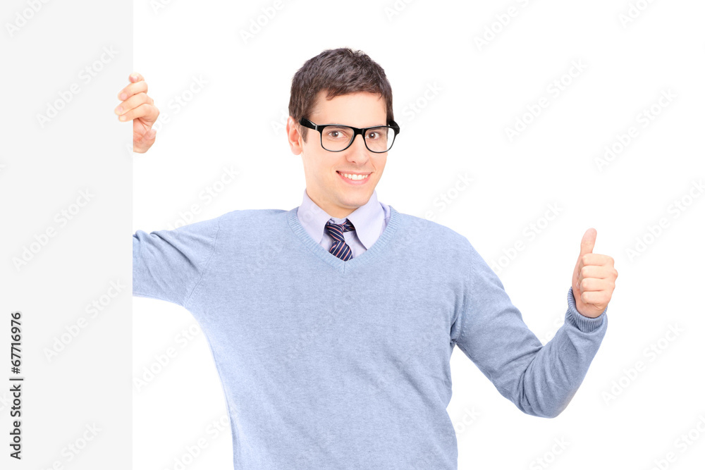 Man giving thumb up standing by a blank panel Man giving thumb up standing by a blank panel