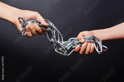 鎖を引き合う二人の人間の手 © beeboys