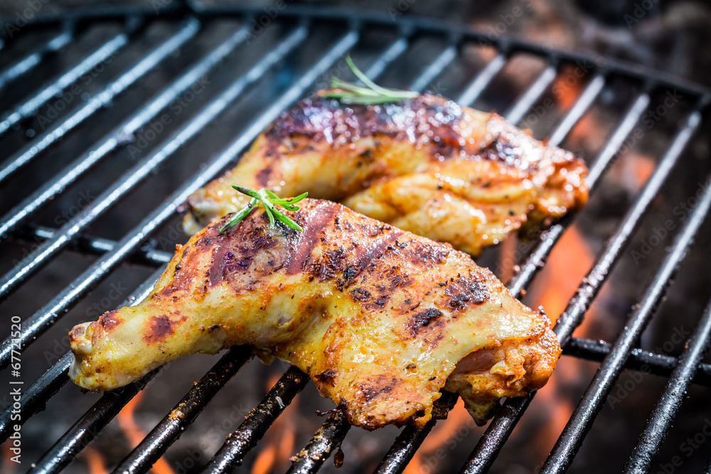 Roasted chicken legs on the grill with fire