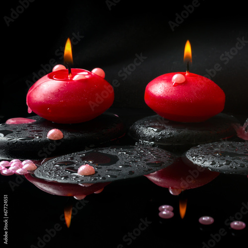 Photography spa concept of  red candles and pearl beads on zen stones with d