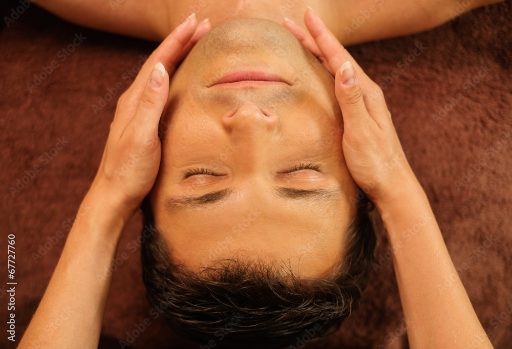 Naklejka premium Handsome man having face massage in spa salon