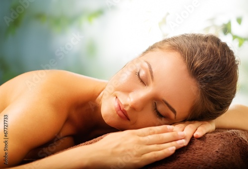 Beautiful young woman relaxing in a spa salon