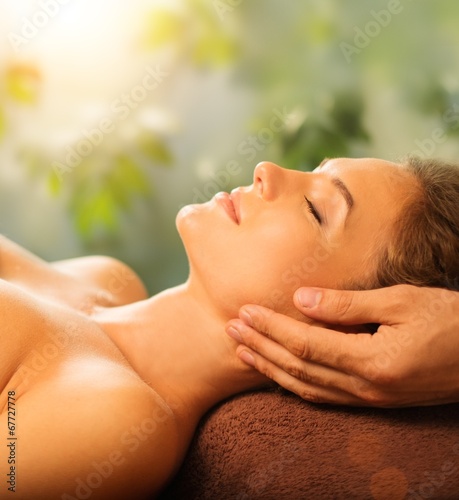 Young woman having face massage in a spa salon
