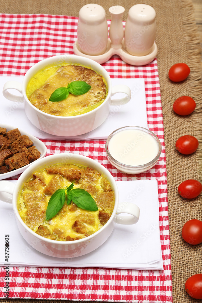 Tasty soup in saucepans on wooden table, close up Tasty soup in saucepans on wooden table, close up
