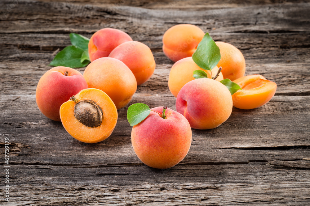 Apricots with leaves on wooden background Apricots with leaves on wooden background