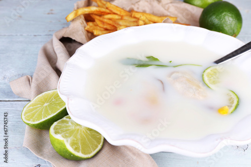 Tasty soup with oysters on wooden table photo