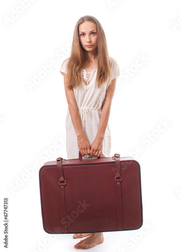 woman lifts a heavy suitcase, isolated on white