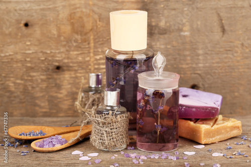 Spa still life with lavender oil and flowers on wooden table