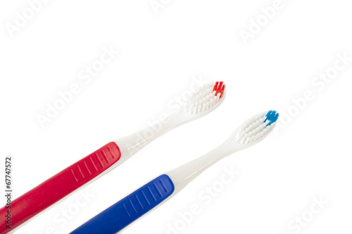 Two toothbrushes of different colors on white