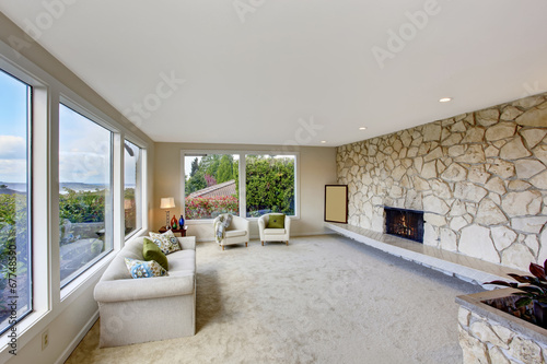 Bright living room with rock wall trim and fireplace
