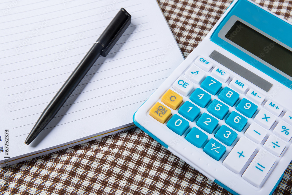 note paper with calculator and pen on table note paper with calculator and pen on table