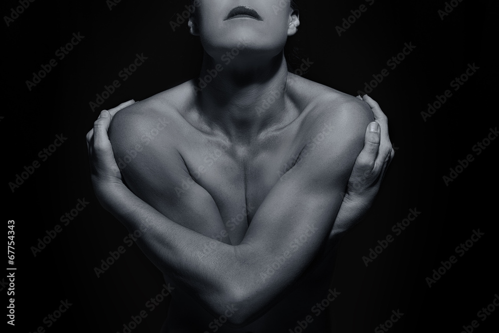 Body scape of woman front with arms crossed in low light emotion